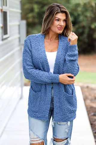 Woman wearing a blue cardigan outdoors