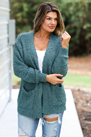 Woman wearing a teal cardigan outdoors