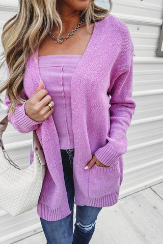 Woman wearing a purple cardigan with a white background