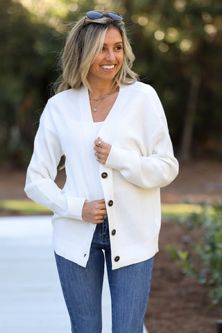 Woman wearing a white cardigan with buttons outdoors